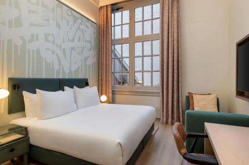 a hotel room with a bed and a window at The College Hotel Amsterdam, Autograph Collection in Amsterdam
