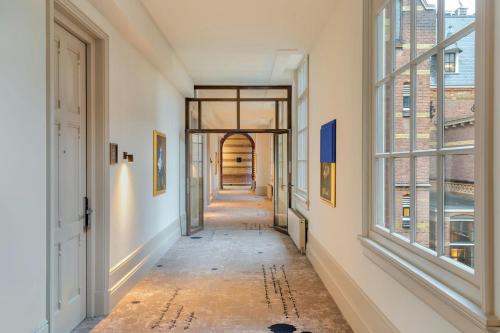 an empty hallway with windows and a hallway with at The College Hotel Amsterdam, Autograph Collection in Amsterdam