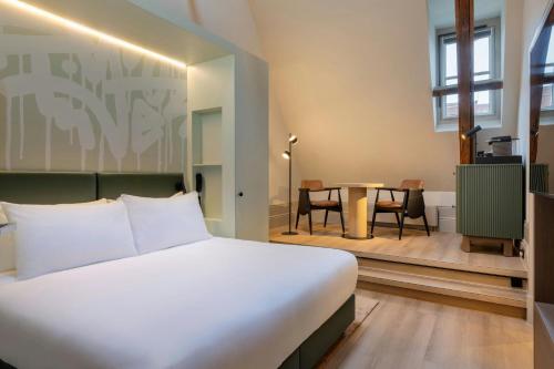 a bedroom with a large bed and a table at The College Hotel Amsterdam, Autograph Collection in Amsterdam