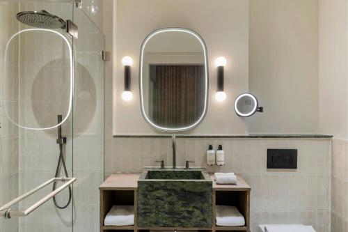 a bathroom with a sink and a mirror at The College Hotel Amsterdam, Autograph Collection in Amsterdam