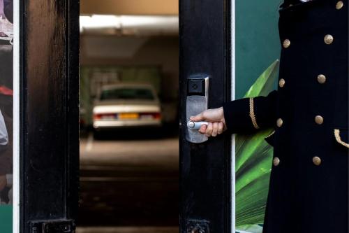 a person opening a door with their hand on it at The College Hotel Amsterdam, Autograph Collection in Amsterdam