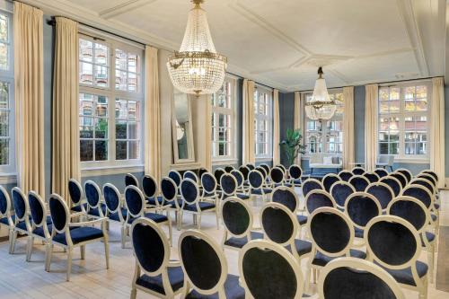 a conference room with chairs and a table and chandeliers at The College Hotel Amsterdam, Autograph Collection in Amsterdam