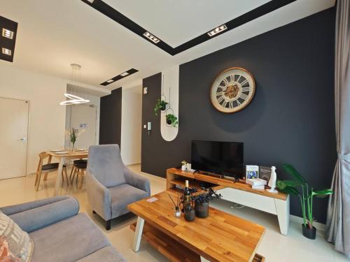 a living room with a couch and a tv and a table at SKS Pavillion Residences Johor Bahru in Johor Bahru
