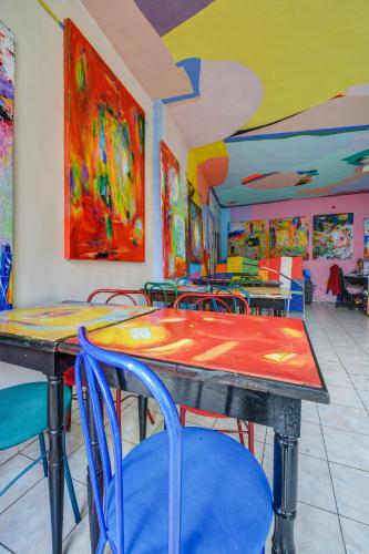 a dining room with colorful tables and chairs at Hotel sebarozvoja s možnosťou získania poznania a inšpirujúcich prostriedkov na uplatňovanie vedomia, premenu seba a prostredia interiéru in Bratislava