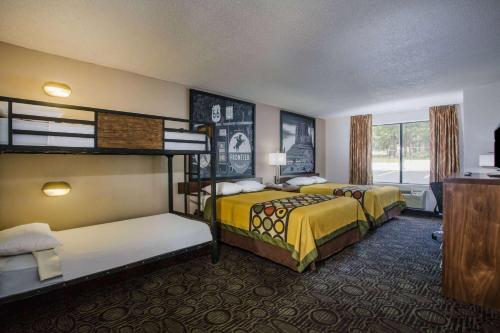 a hotel room with two beds and a television at Super 8 by Wyndham Flagstaff in Flagstaff