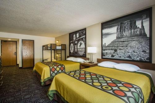 a hotel room with two beds and a picture on the wall at Super 8 by Wyndham Flagstaff in Flagstaff