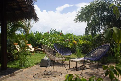 a group of chairs sitting on a patio at MADIROKELY HOUSE Nosy Be in Ambatoloaka