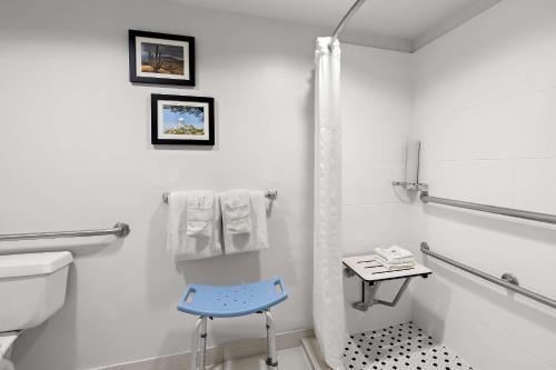 a bathroom with a toilet and a blue chair at Comfort Inn & Suites near Kino Sports Complex in Tucson