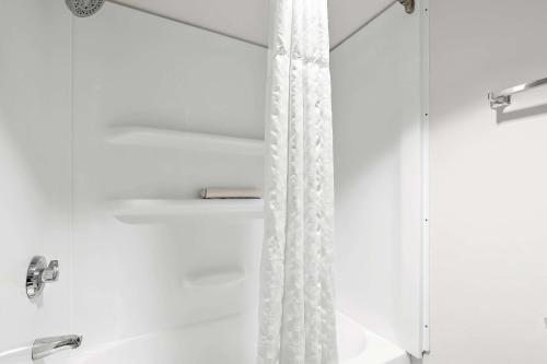a shower with a white shower curtain in a bathroom at Comfort Inn & Suites near Kino Sports Complex in Tucson