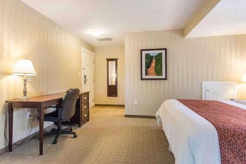 a hotel room with a desk and a bed at Quality Inn & Suites Downtown in Charlottetown