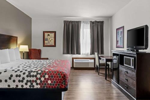 a hotel room with a bed and a desk and a television at FairBridge Inn Express Billings Airport in Billings