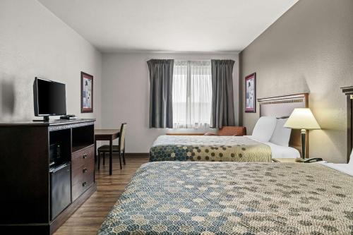 a hotel room with two beds and a flat screen tv at FairBridge Inn Express Billings Airport in Billings