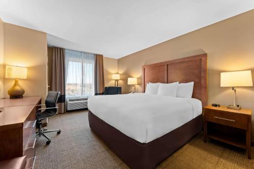 a hotel room with a large bed and a desk at Comfort Inn & Suites Avera Southwest in Sioux Falls