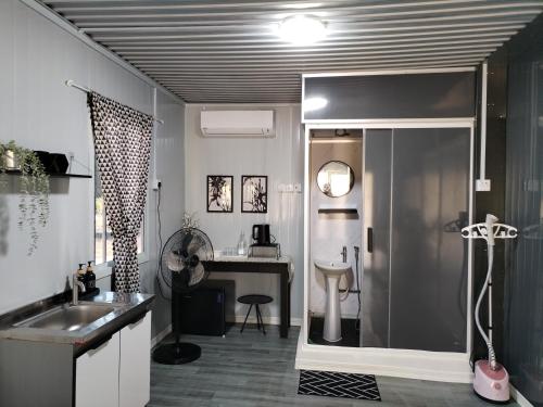 a bathroom with a shower and a sink and a desk at The Vanilla Cabin 2 in Kuala Terengganu