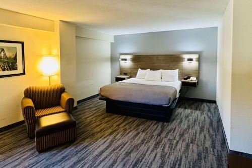 a hotel room with a bed and a chair at Quality Inn Danville - University Area in Danville