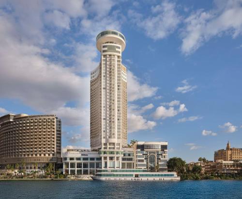 a tall white building with a round tower on top at Hilton Cairo Grand Nile in Cairo