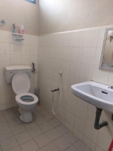 a bathroom with a toilet and a sink at Puteh House Kemaman in Kampong Jaya