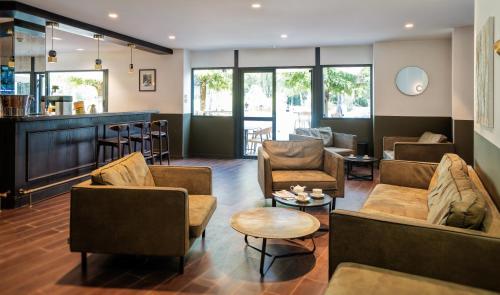 a lobby with couches and chairs and a bar at Domaine de Charmeil in Saint-Quentin-sur-Isère