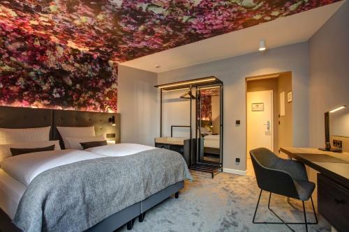 a bedroom with a large bed with a flowery ceiling at Vienna House Easy by Wyndham Hamburg City in Hamburg