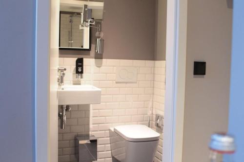 a bathroom with a toilet and a sink at Vienna House Easy by Wyndham Hamburg City in Hamburg