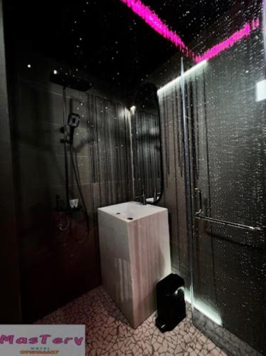 a bathroom with a shower and a white toilet at Mastery Hotel Nhà Bè in Ho Chi Minh City