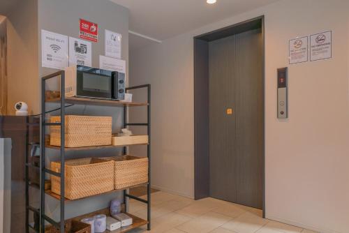 a room with a door and a shelf with baskets at JA Hotel Namba South in Osaka