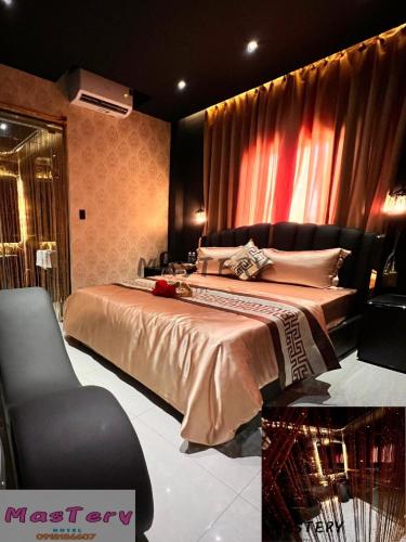 a bedroom with a large bed and a chair at Mastery Hotel Nhà Bè in Ho Chi Minh City