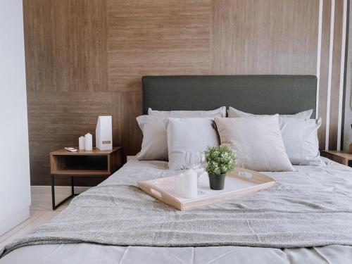 a bed with a tray with a plant on it at Cozy Kenwingston Platz KL 2-5 Pax 2BR & 2BR FrePakin Netflix 2802 in Kuala Lumpur