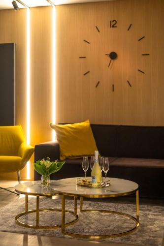 a living room with a table and a clock on the wall at Apartamenty Fenomen - Premium Porto Nadmorskie Tarasy w Kołobrzegu in Kołobrzeg