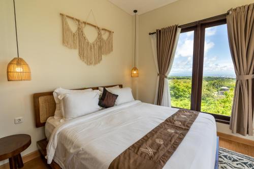 une chambre avec un lit et une grande fenêtre dans l'établissement Green GWK Villa, à Jimbaran