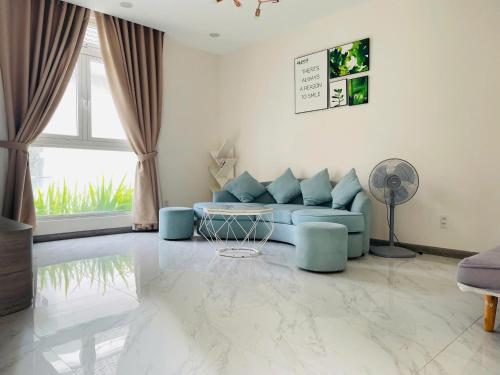 a living room with a blue couch and a window at Lavini Đà Lạt House and Apartment in Da Lat