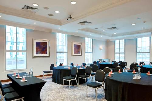 a conference room with tables and chairs and windows at Delta Hotels by Marriott Birmingham in Birmingham
