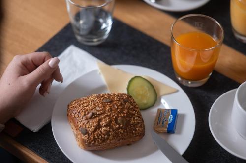 a plate of food with a sandwich and a drink at Roots Hotel Restaurant in Gomaringen