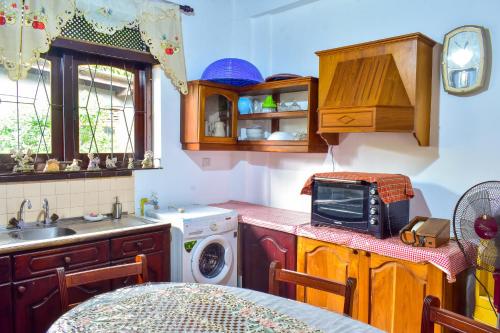 a kitchen with a sink and a microwave at Wicks Backpacker's Lodge - Peaceful Quality stay, Walk to the Historic Galle Dutch Fort and the beach in Galle