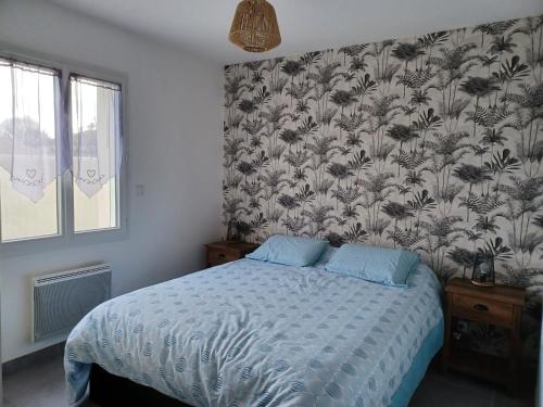 une chambre avec un lit avec un papier peint fleuri dans l'établissement Maison de vacances 6 personnes, à Muron