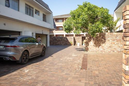 un'auto parcheggiata in un vialetto accanto a un edificio di Aluz Guestunit, Self-catering a East London