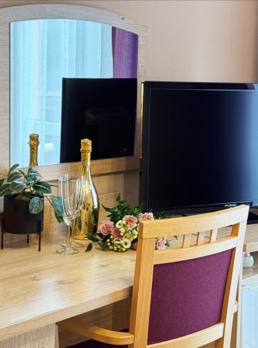 a television sitting on a wooden table with a chair at Dworek nad Wisłą in Wisła