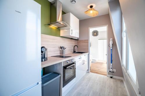 une cuisine avec un évier et une cuisinière dans l'établissement Appartement Rouen Le Stella Hyper Centre à 10 minutes, à Rouen