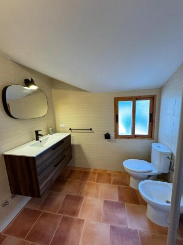 a bathroom with a sink and a toilet and a mirror at La lobera in Arroyo Frio