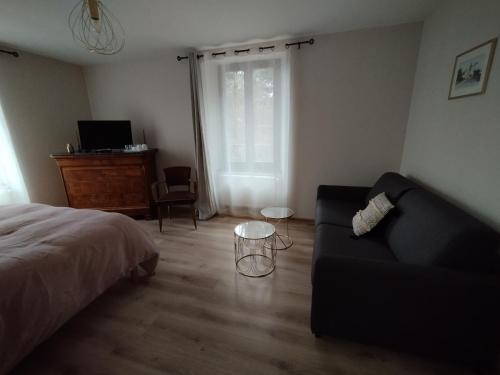 a living room with a bed and a couch at Chambre d'hôte La Suite Domaine du Bagnerot in La Chapelle-aux-Bois