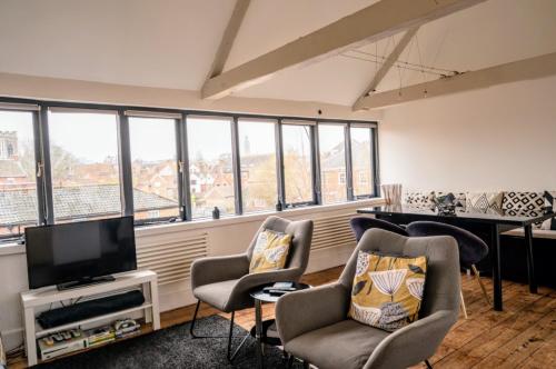 a living room with a piano and chairs and a television at Contractor and Family friendly Grade II townhouse- 3 bedrooms- free parking in Norwich