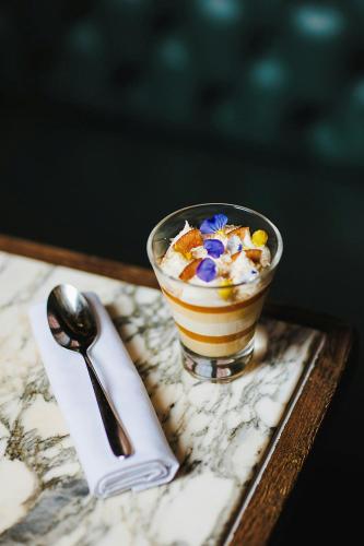 a dessert in a cup on a tray with a spoon at Stock Exchange Hotel, Manchester, Autograph Collection in Manchester