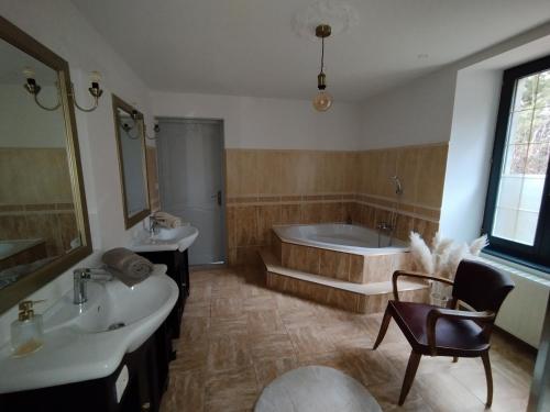 a bathroom with two sinks and a bath tub at Chambre d'hôte La Suite Domaine du Bagnerot in La Chapelle-aux-Bois