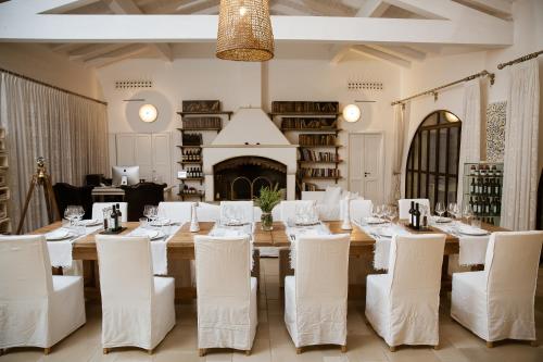 a dining room with a long table and white chairs at Masseria Fano Relais & Wine in Salve