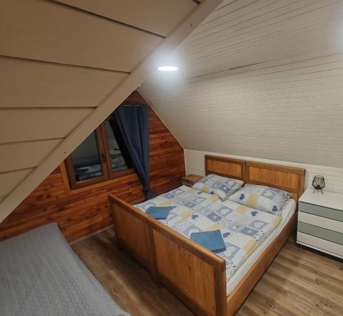 a bedroom with a bed in a attic at Cabin near forest in Mlynčeky