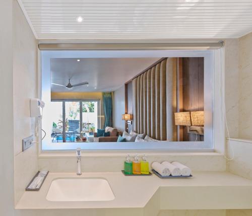 a bathroom with a sink and a large mirror at Shivsagar Resort & Spa in Mahabaleshwar