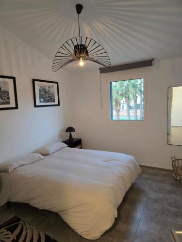 a bedroom with a large white bed with a ceiling at Cozy apartment - Beach 100m away in Sa Caleta