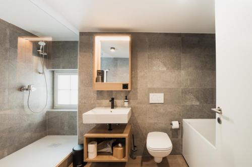 a bathroom with a sink and a toilet and a mirror at Hotel Brocco & Posta in San Bernardino