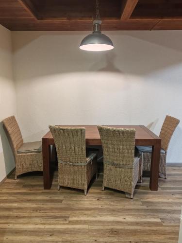 a dining room table with chairs and a light at Cabin near forest in Mlynčeky