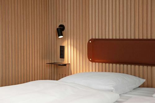 a bedroom with a bed with a light on the wall at Four Points Flex by Sheraton Horsens in Horsens